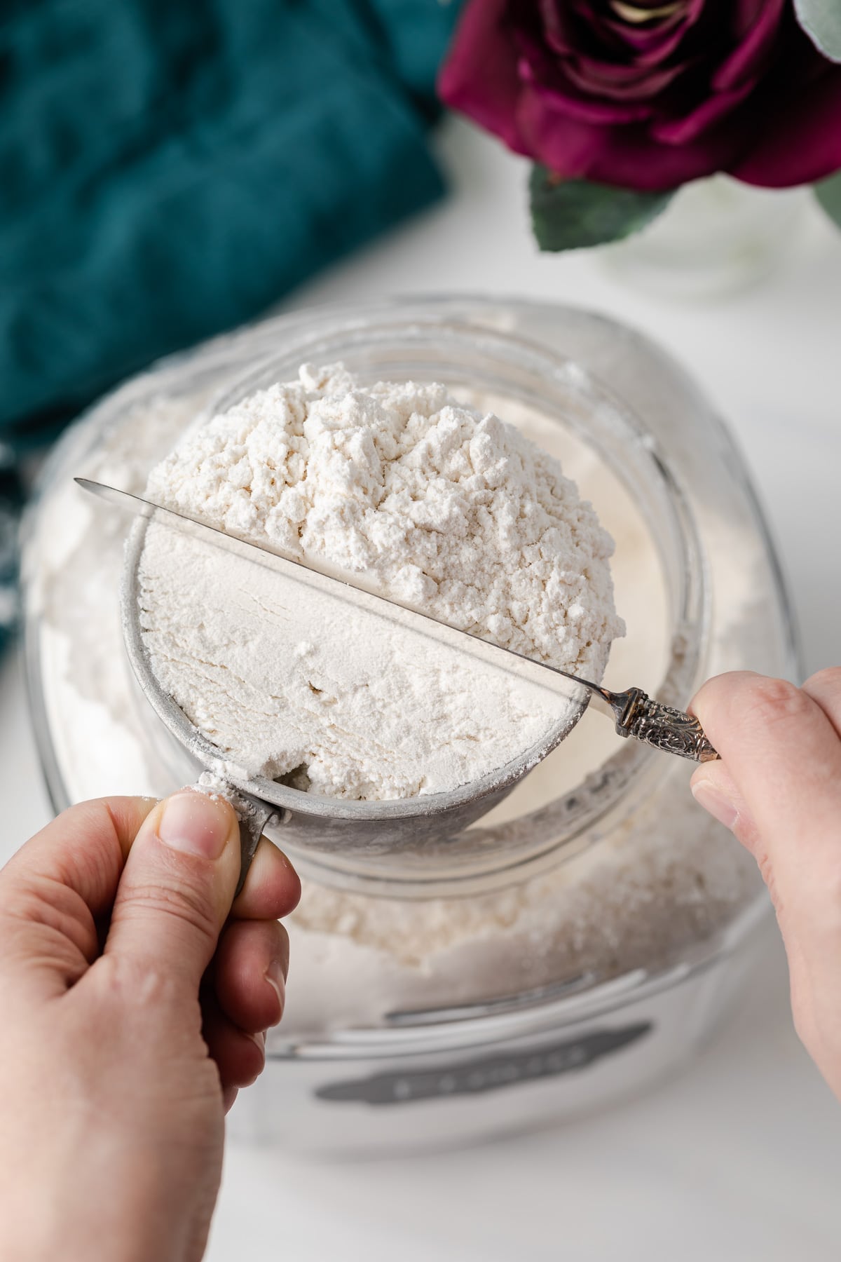 leveling flour in measuring cup with a knife