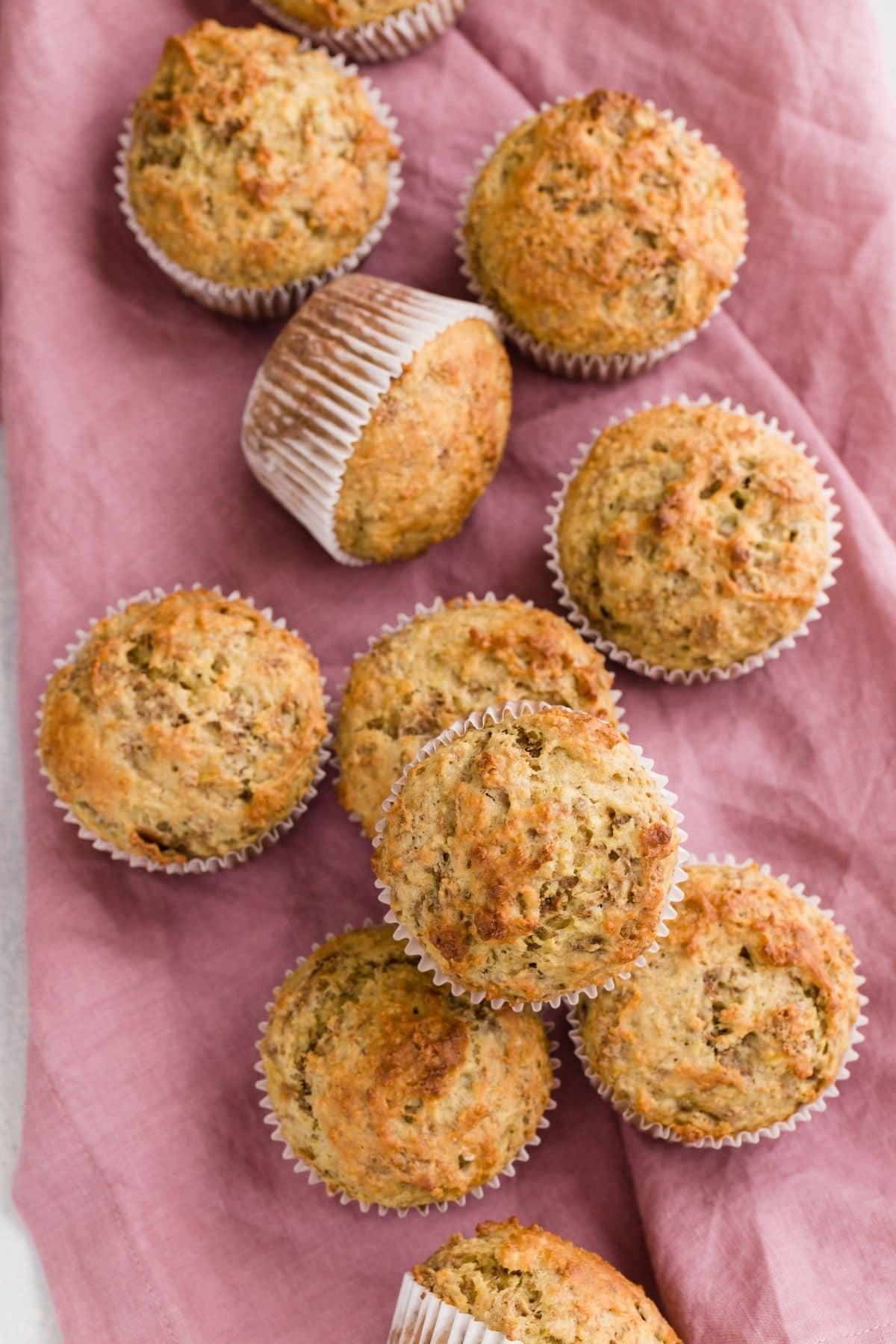 Banana Bran Muffins scattered on a pink napkin.
