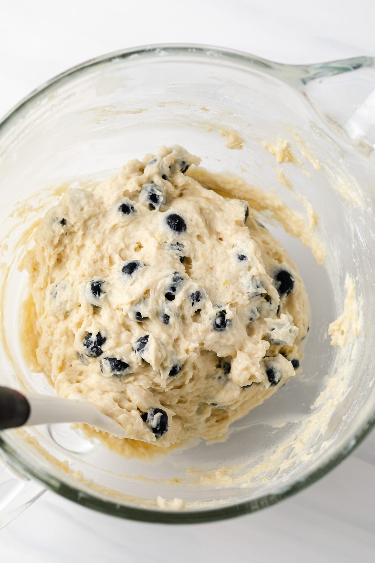 muffin batter with blueberries in glass bowl