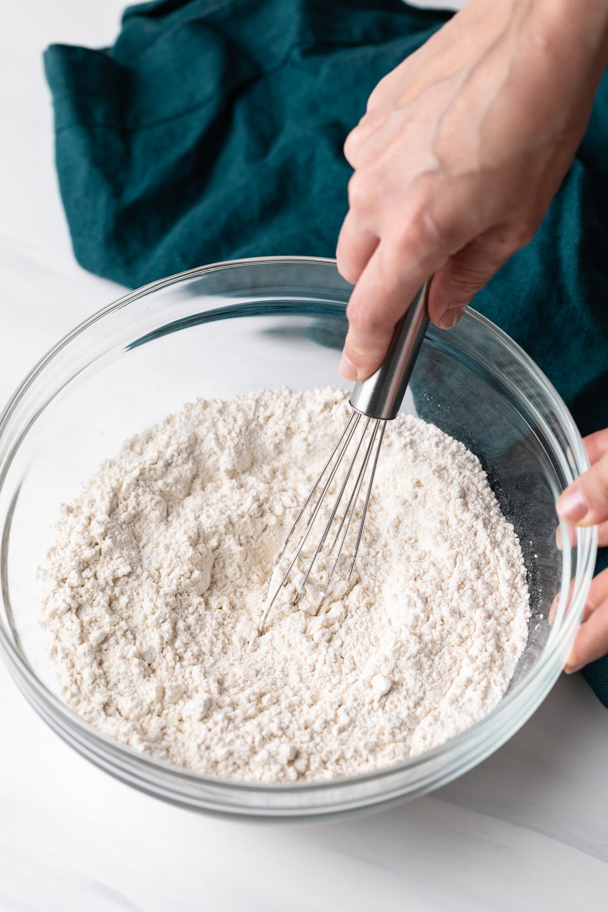 mixing flour with whisk in glass bowl