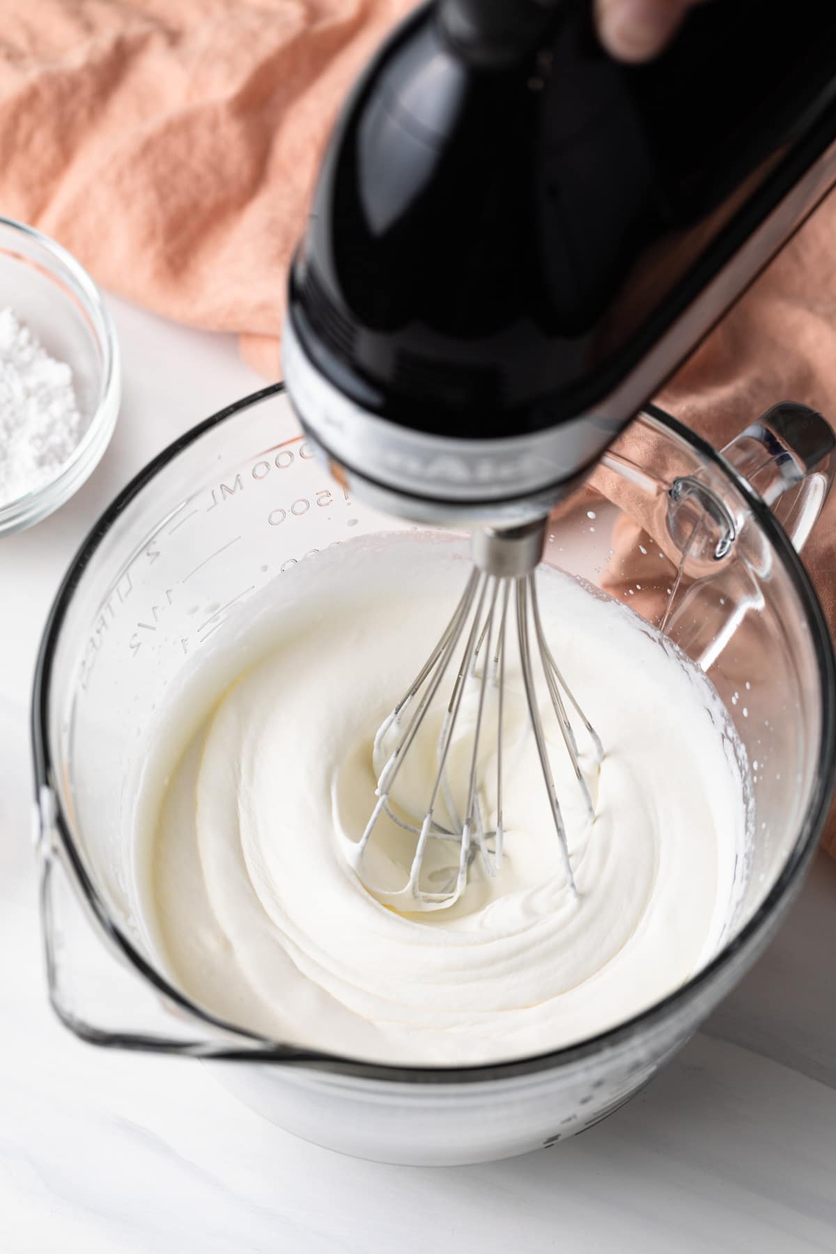 mixer whipping cream in a glass bowl