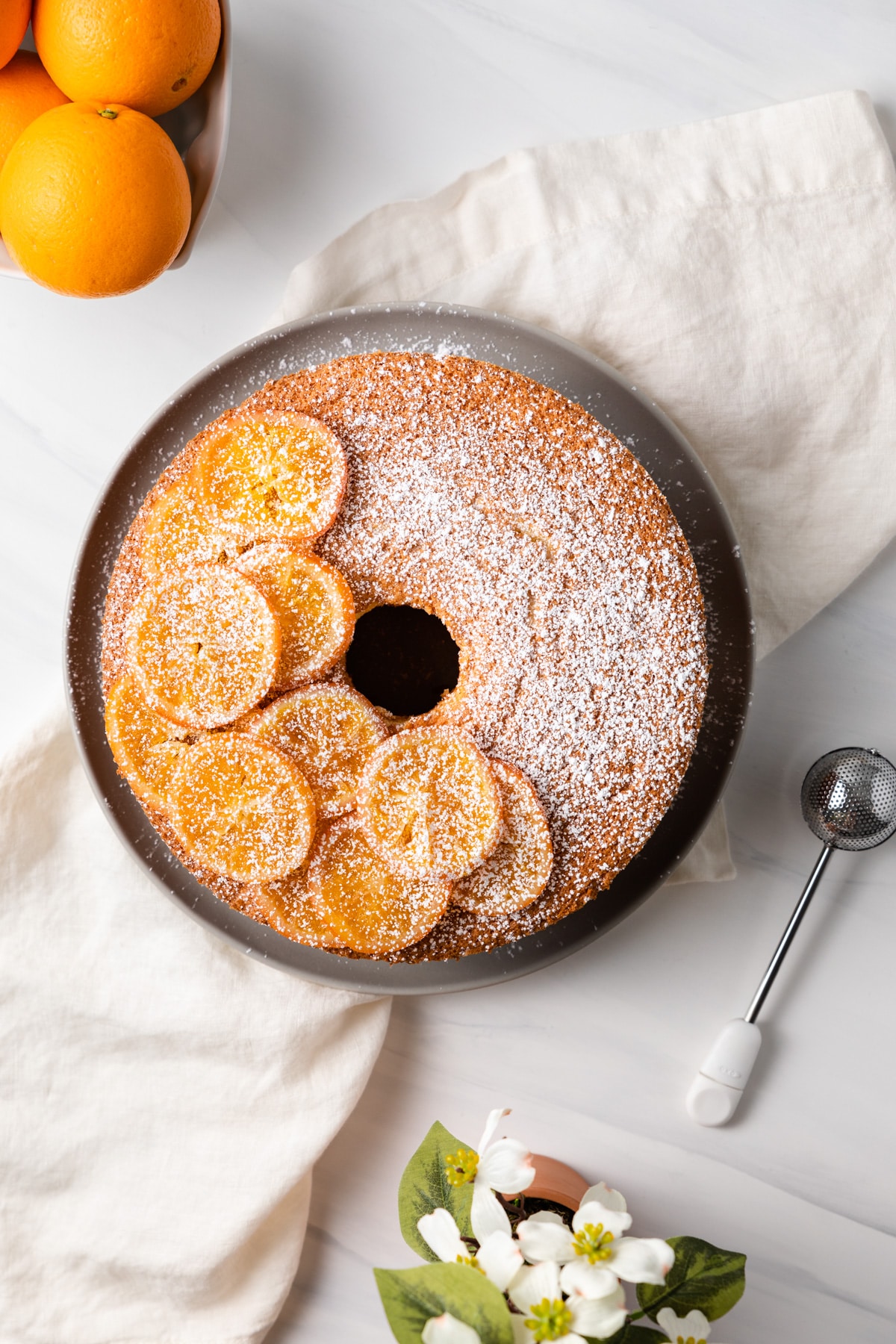 overhead of orange chiffon cake decorated with candy orange slices and powdered sugar