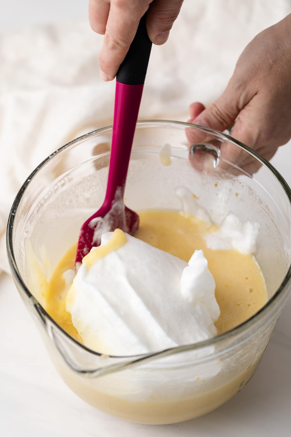 egg whites added to chiffon cake batter in glass bowl