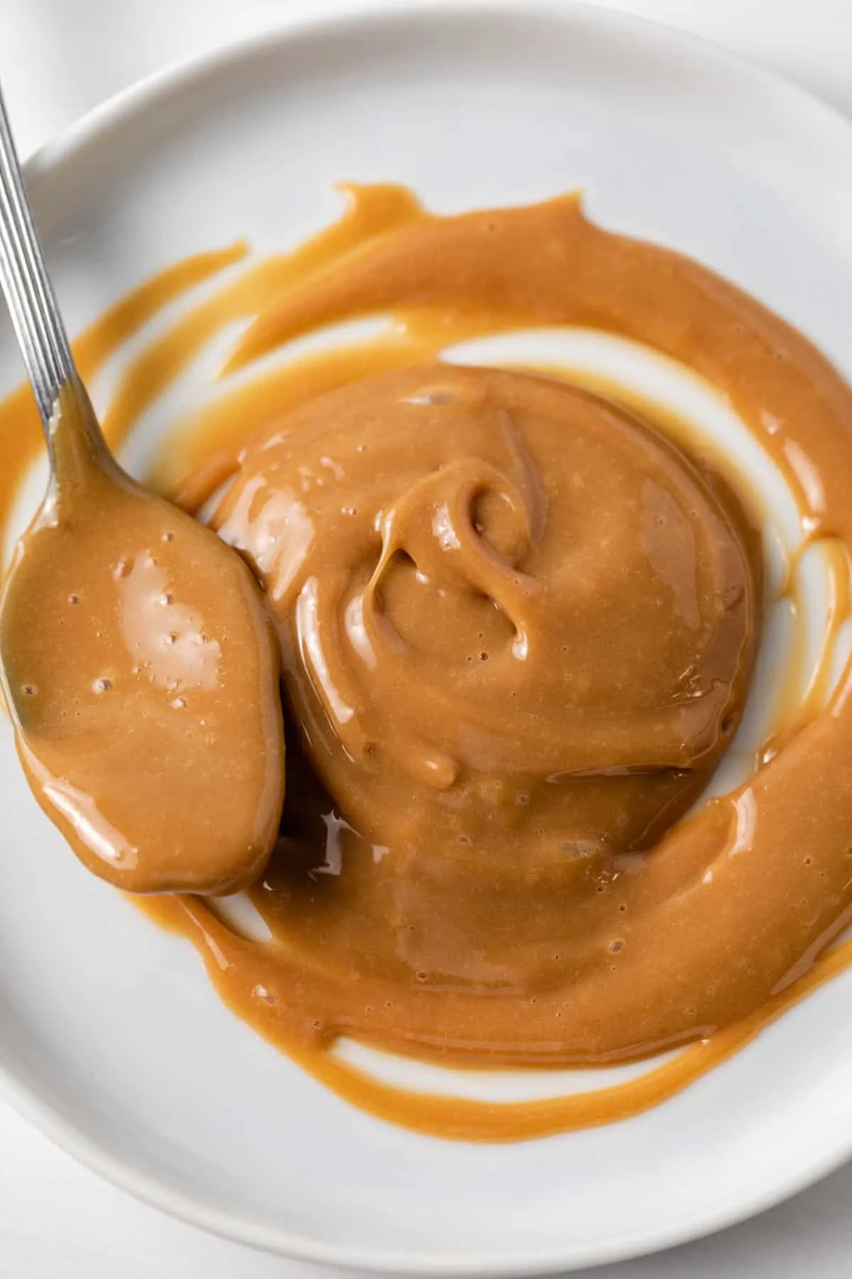 dulce de leche spread on white plate with spoon