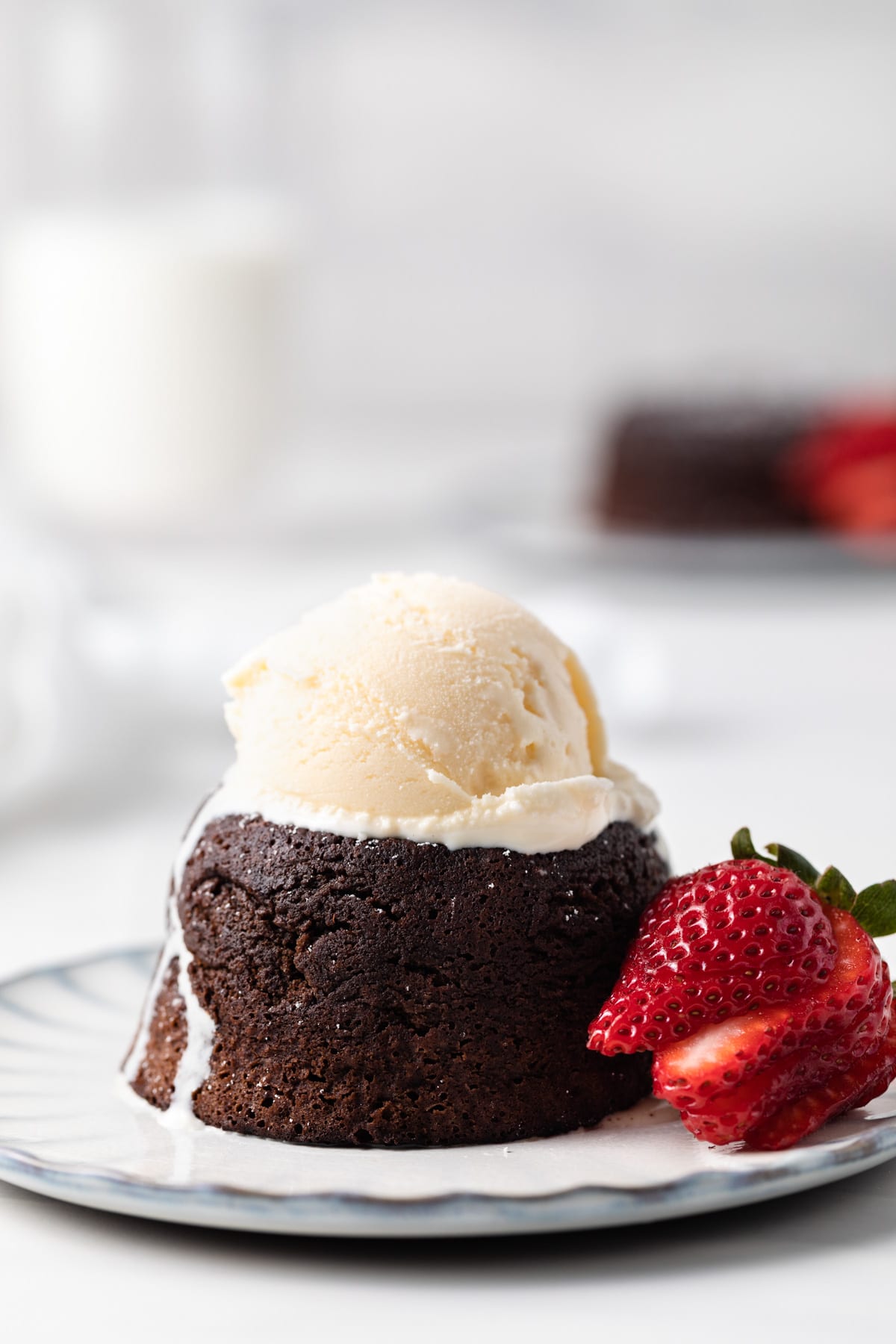 side view of individual molten lava cake with scoop of ice cream on top