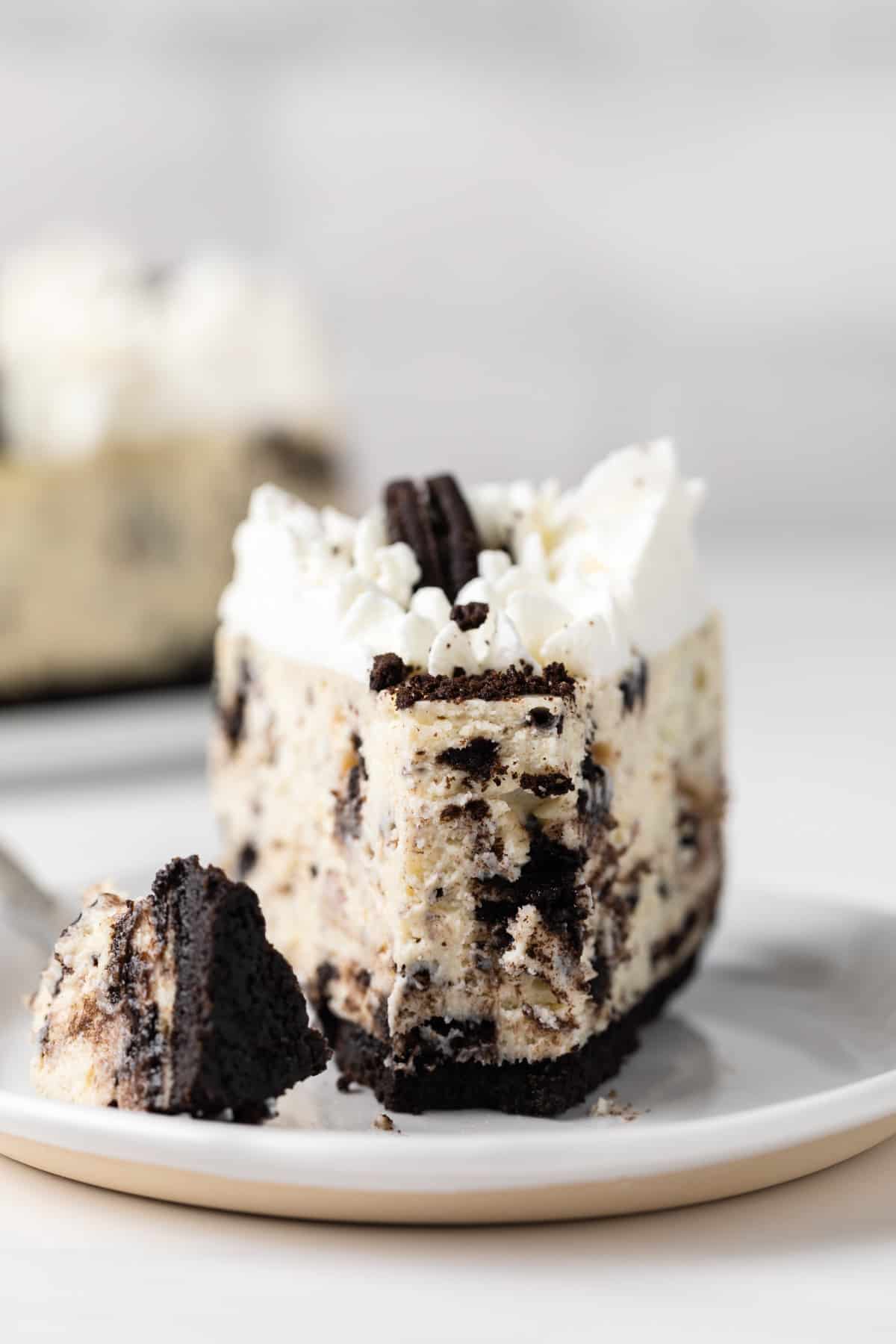 front view of slice of oreo cheesecake with a bite taken out on a fork