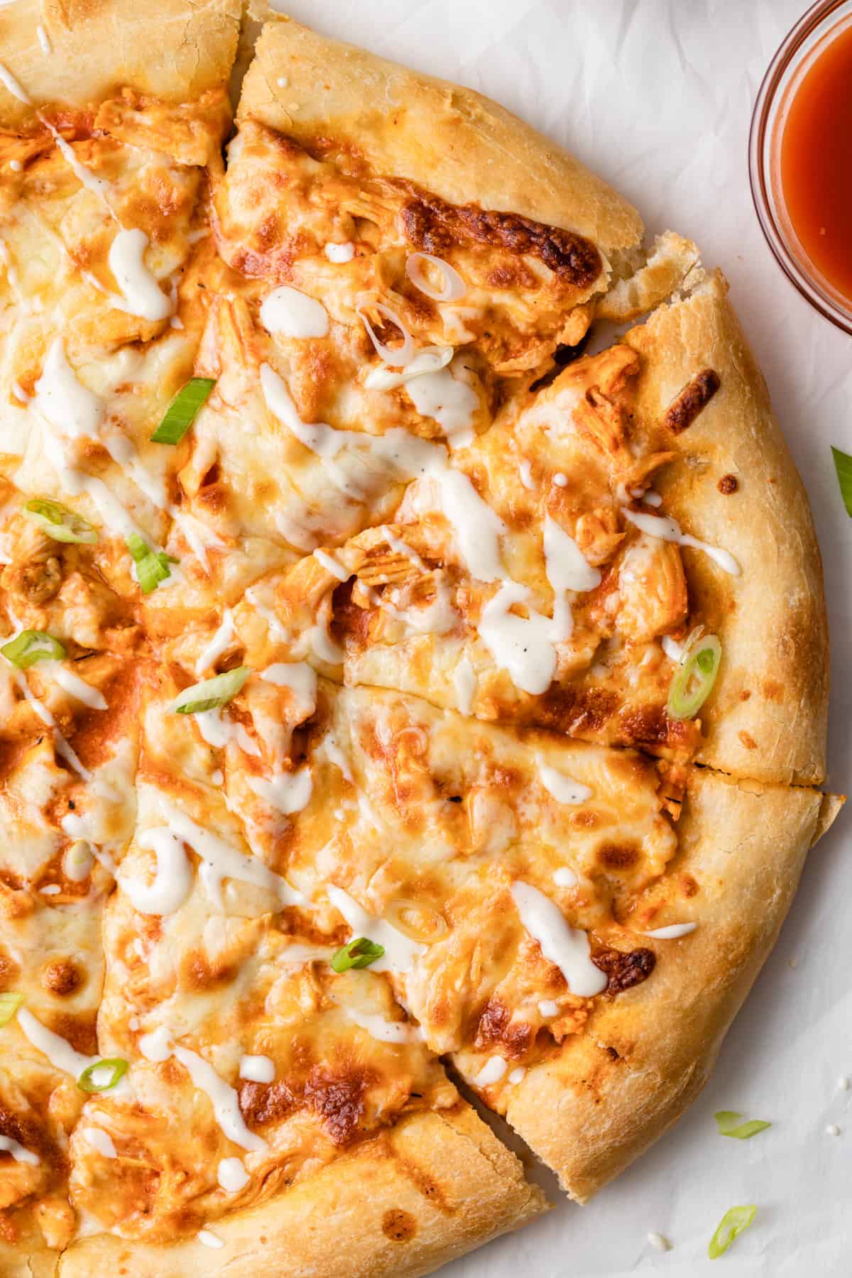 close up overhead view of buffalo chicken pizza sliced