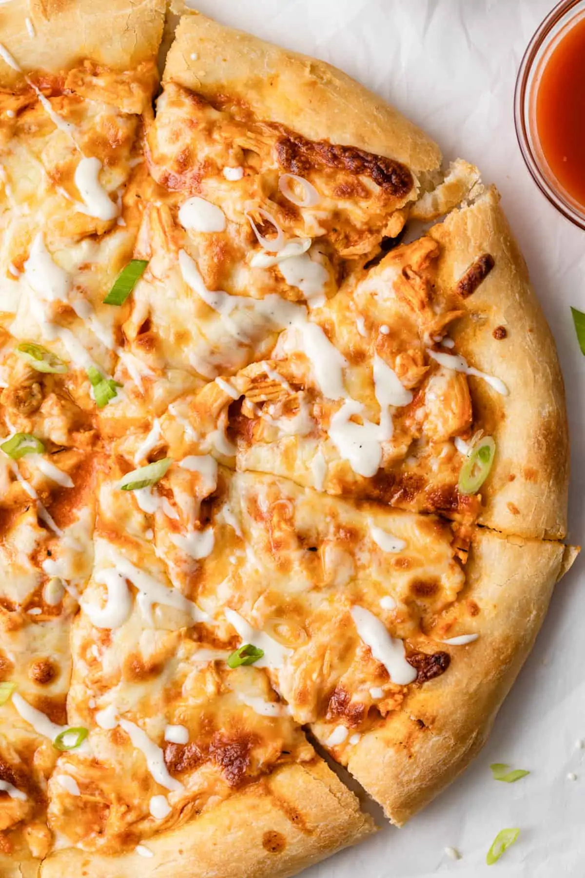 close up overhead view of buffalo chicken pizza sliced