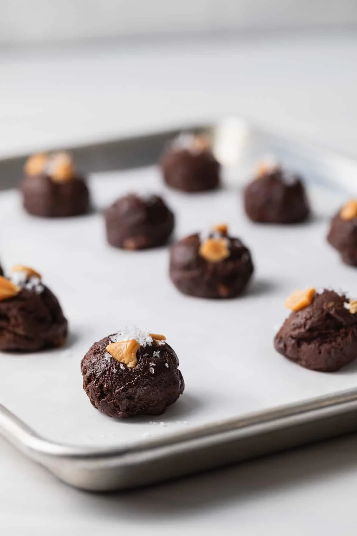 unbaked brownie cookies on a baking sheet lined with parchment paper