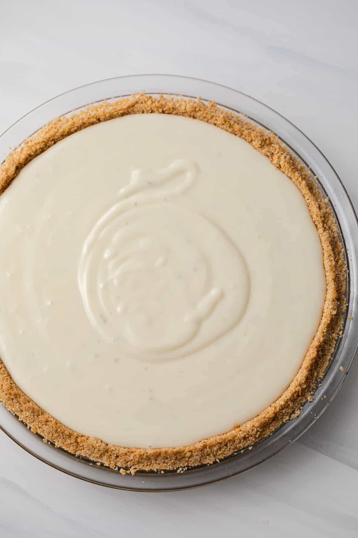 overhead of unbaked key lime pie in glass pie pan