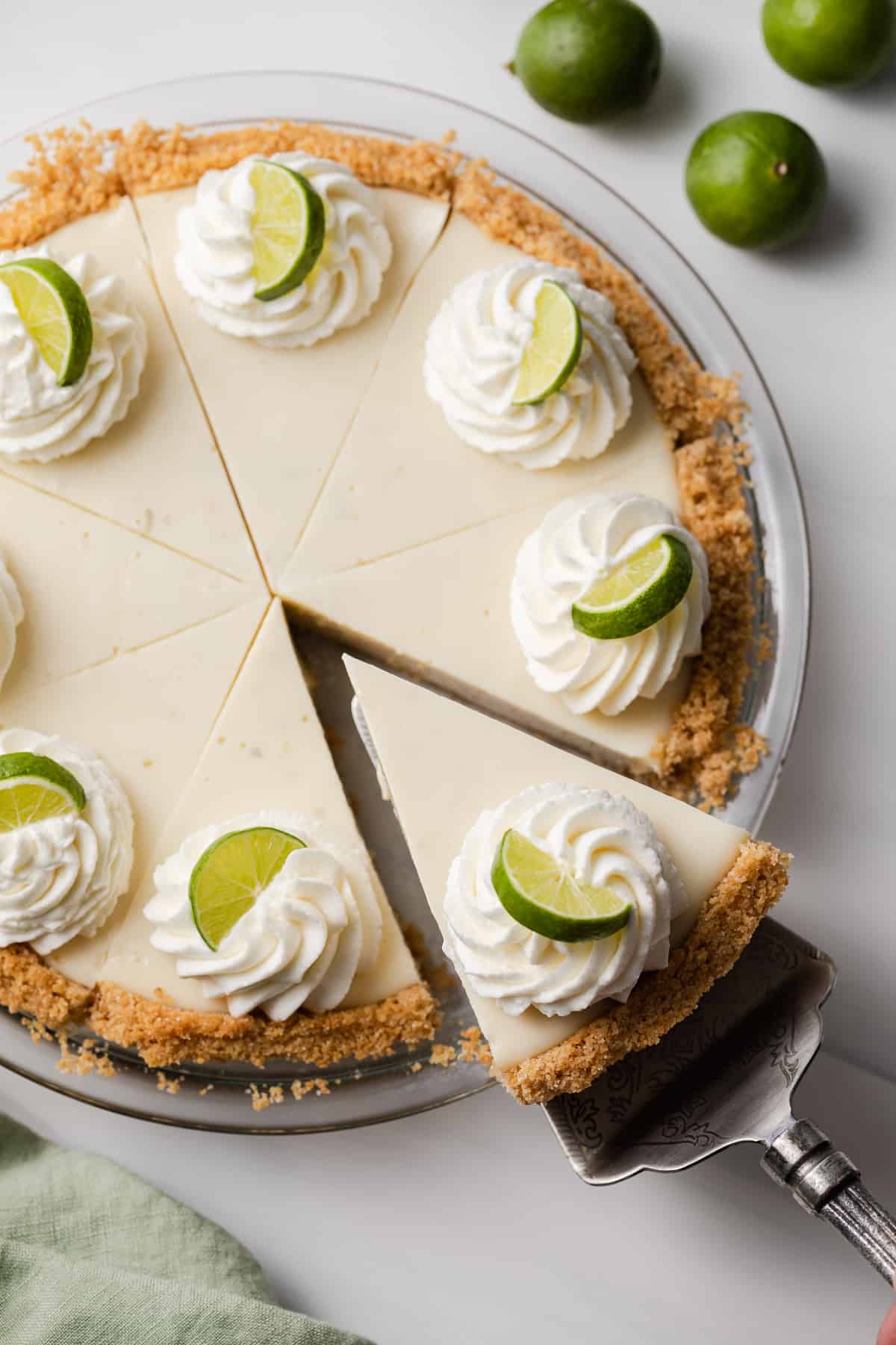 slice of homemade key lime pie being pulled out of whole pie