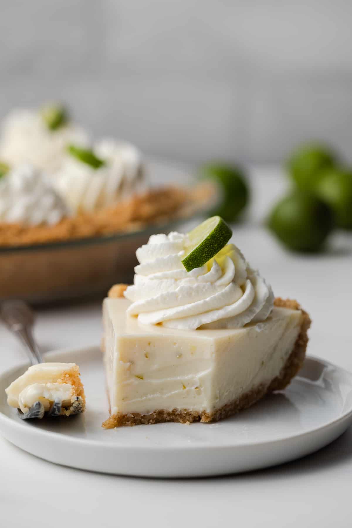 close up view of slice of key lime pie with a bite taken out