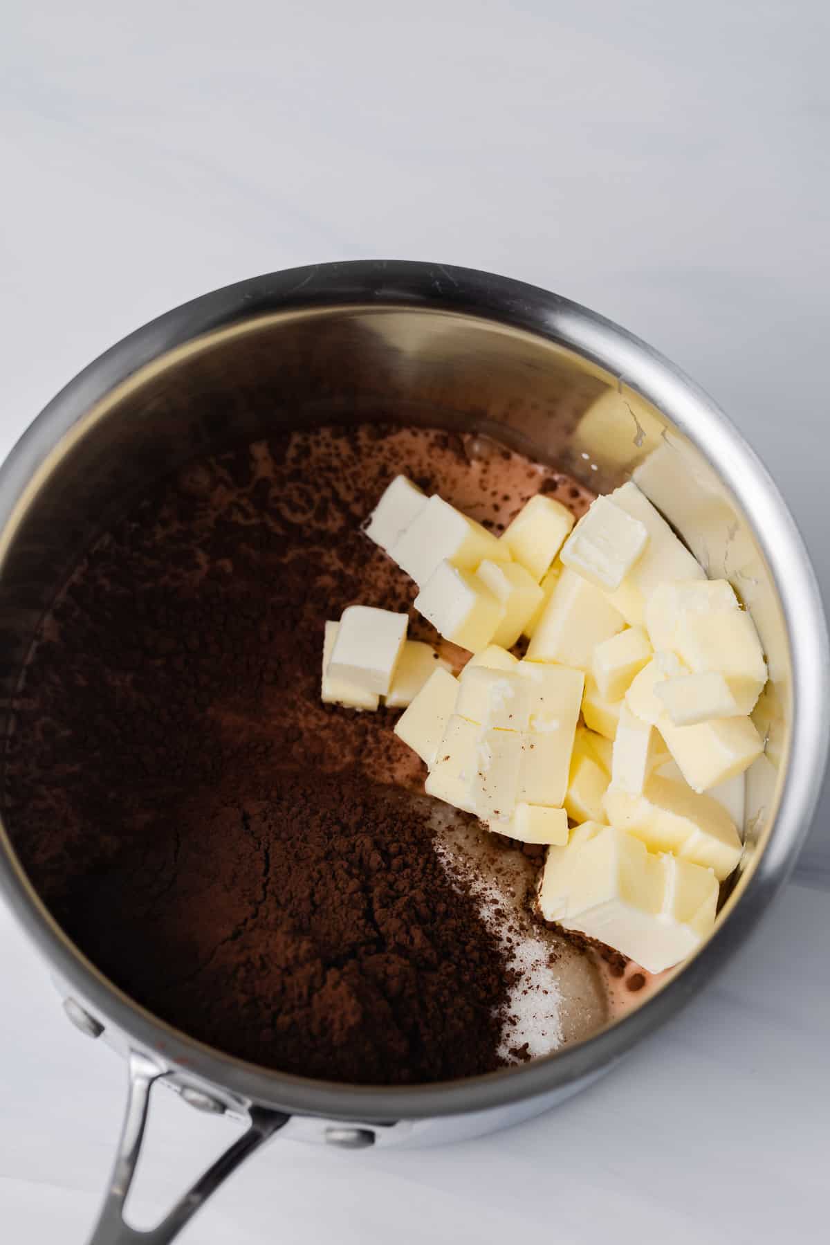 Pot with sugar, milk, butter, and cocoa powder.