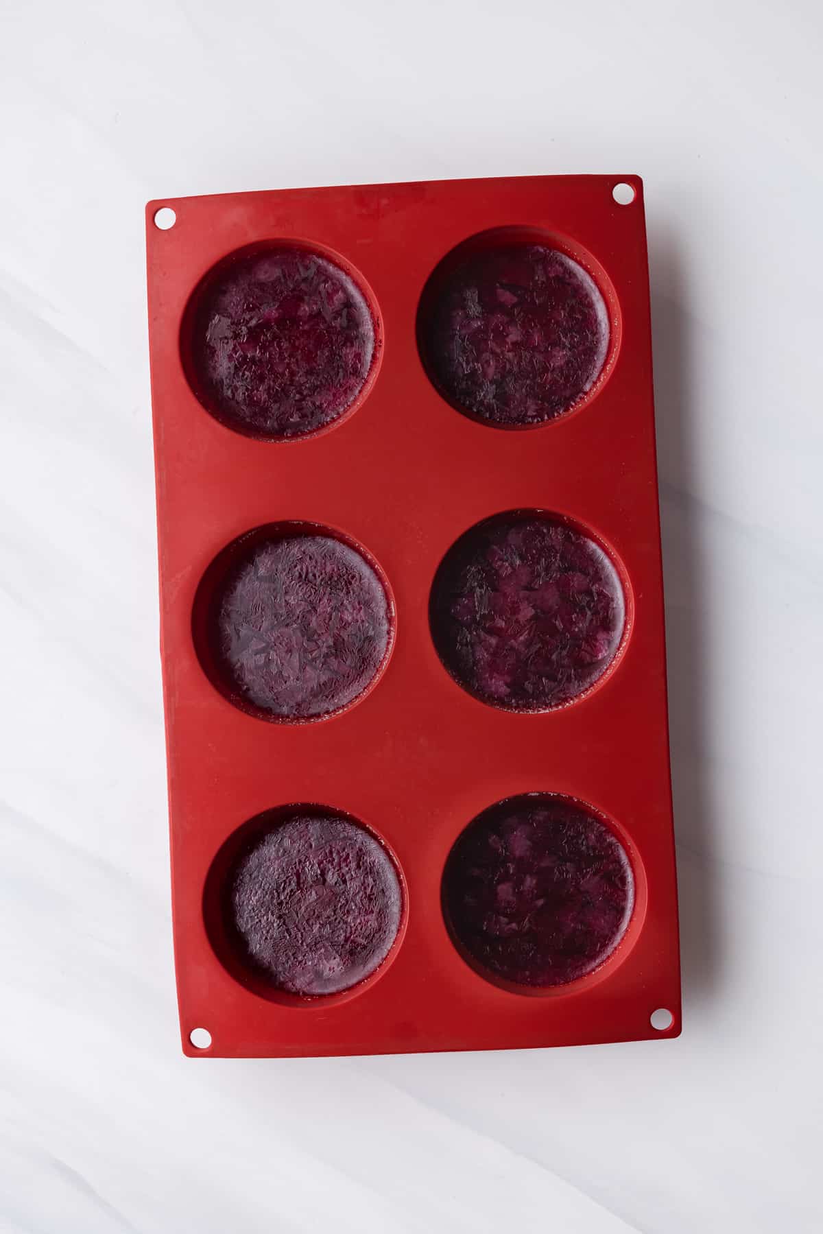 Frozen pomegranate juice in red dome molds.