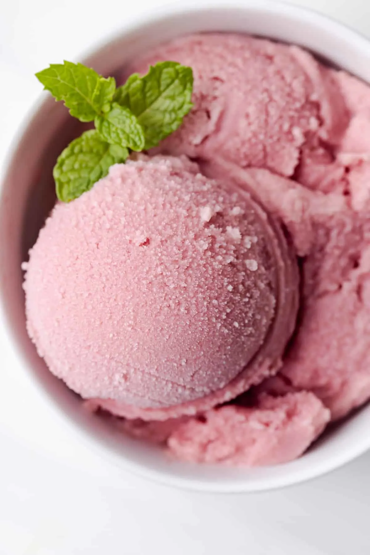 Overhead view of watermelon sorbet in scooped into bowl.