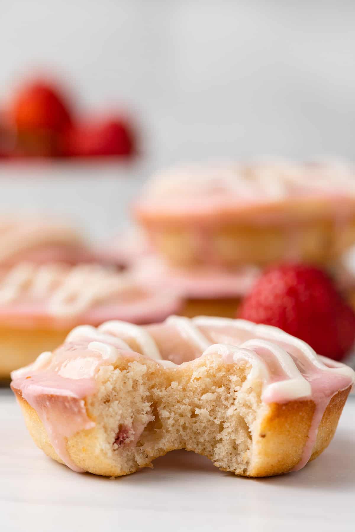 Strawberry cake donut with a bite taken out