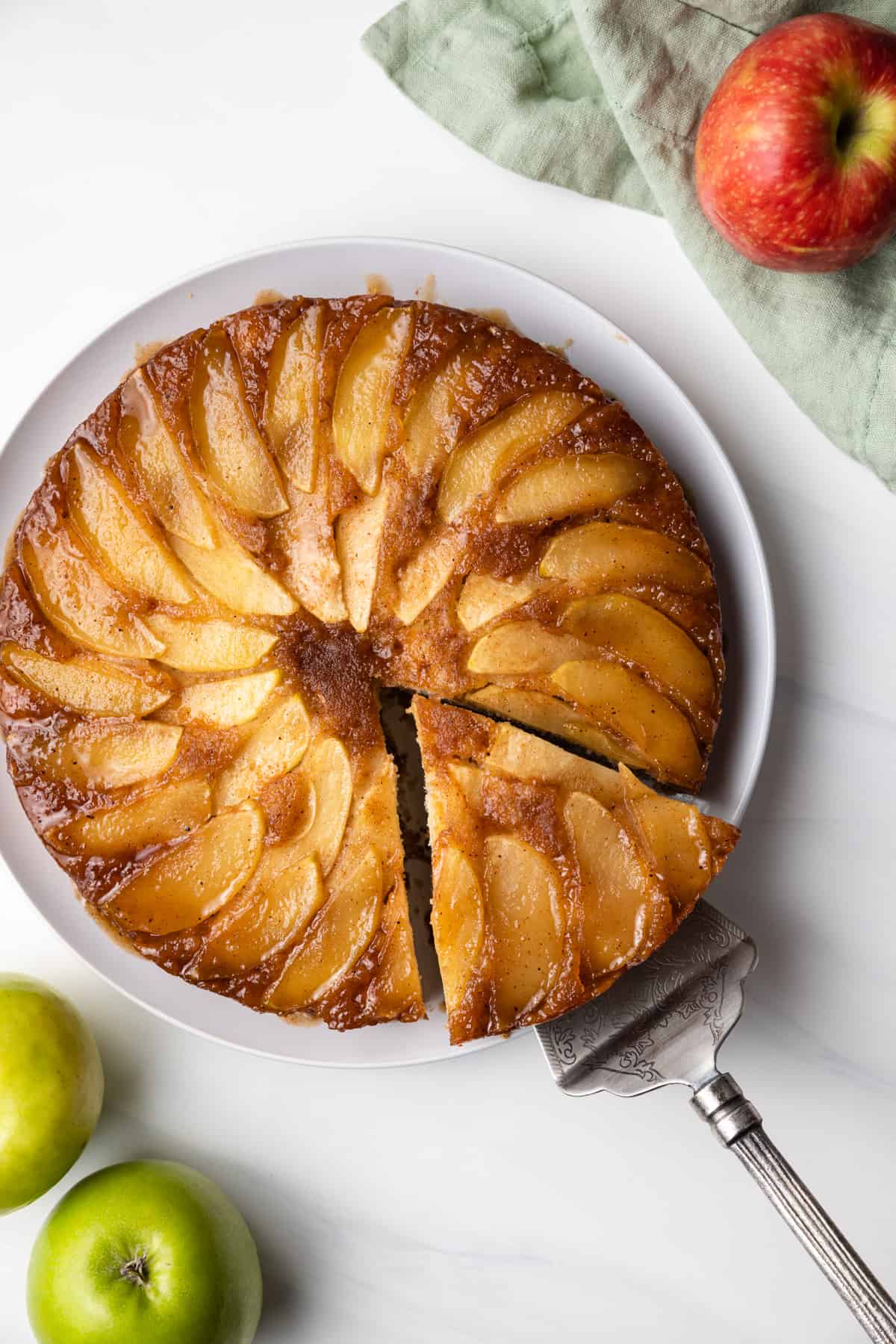 Apple upside down cake with a slice being taken out.