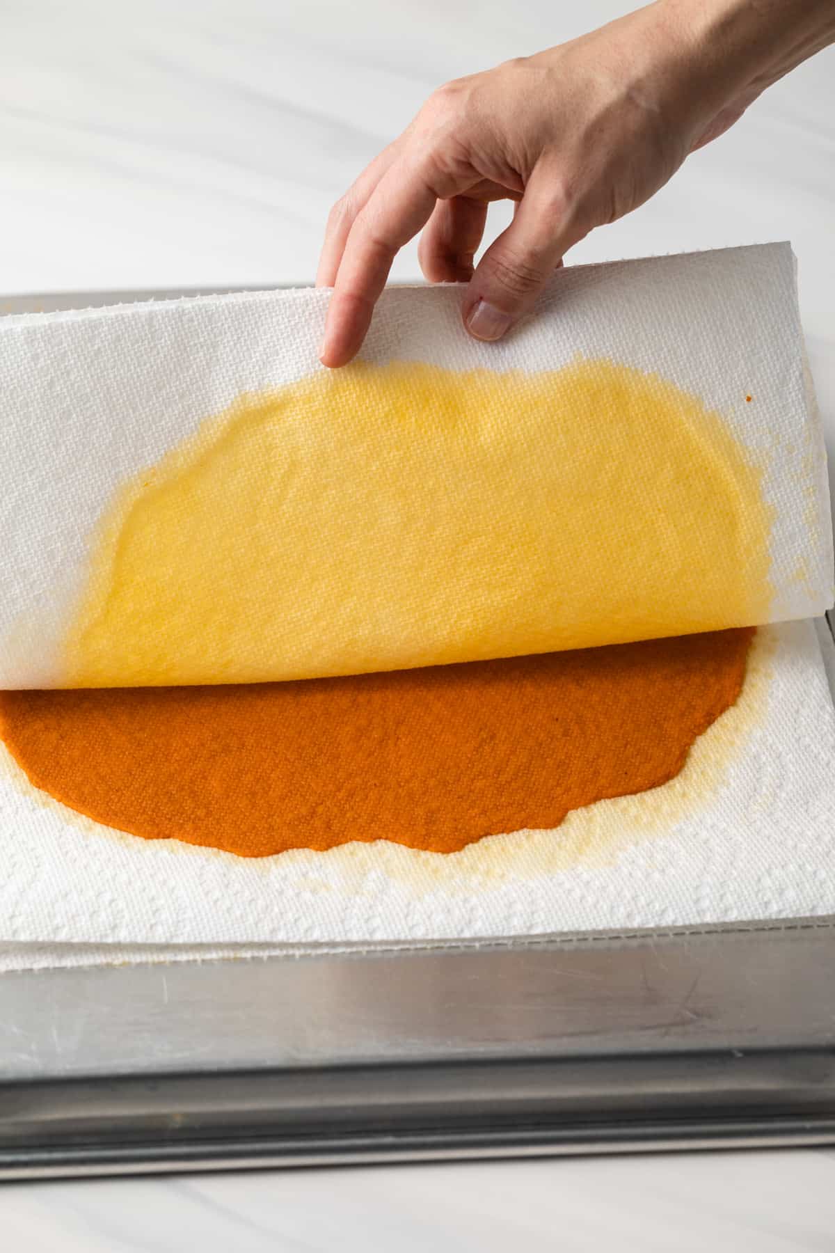 Paper towels being pulled away from pumpkin puree