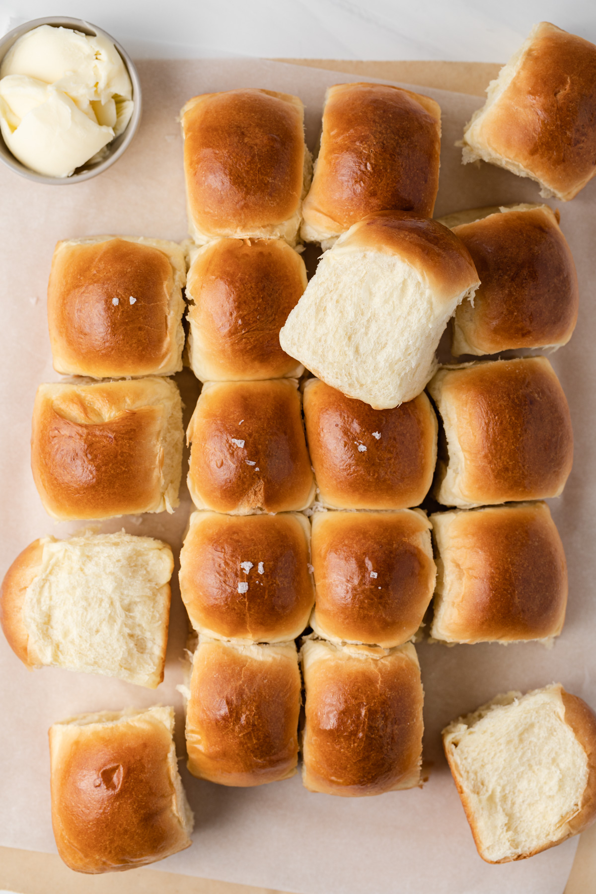 Dinner rolls with some torn apart and turned on their side