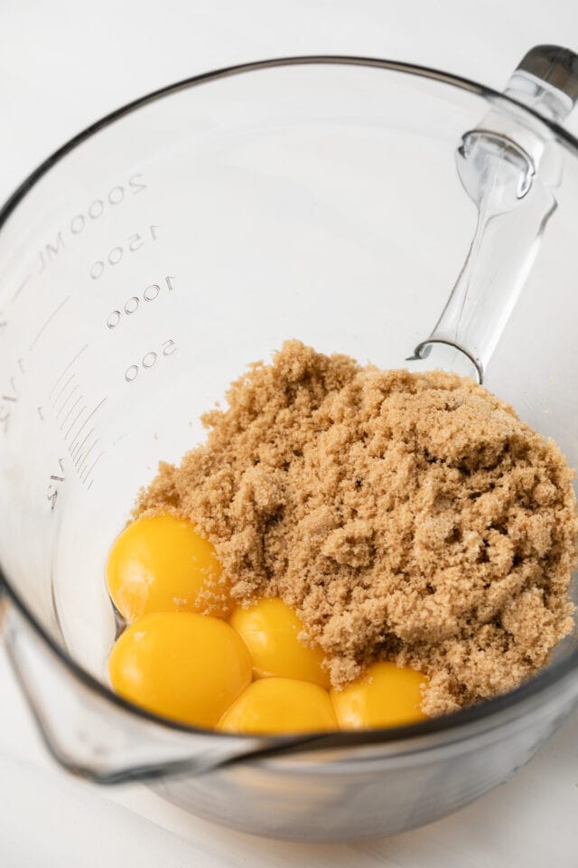 Brown sugar and eggs in glass bowl.