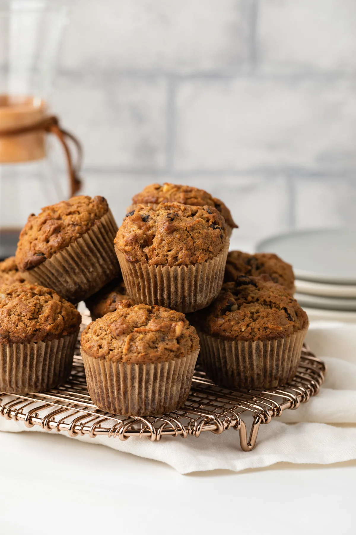 Morning glory muffins stacked on wire rack.