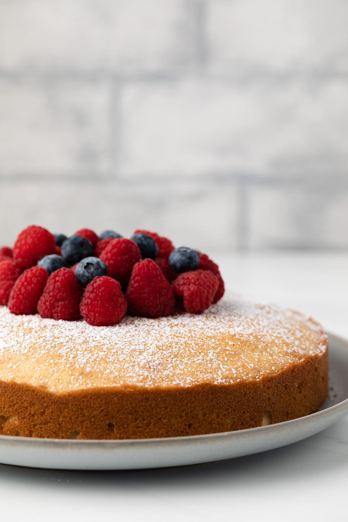 Side view of Irish tea cake topped with fresh berries.