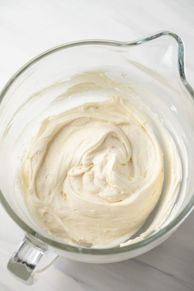 Cream cheese frosting in a glass bowl.