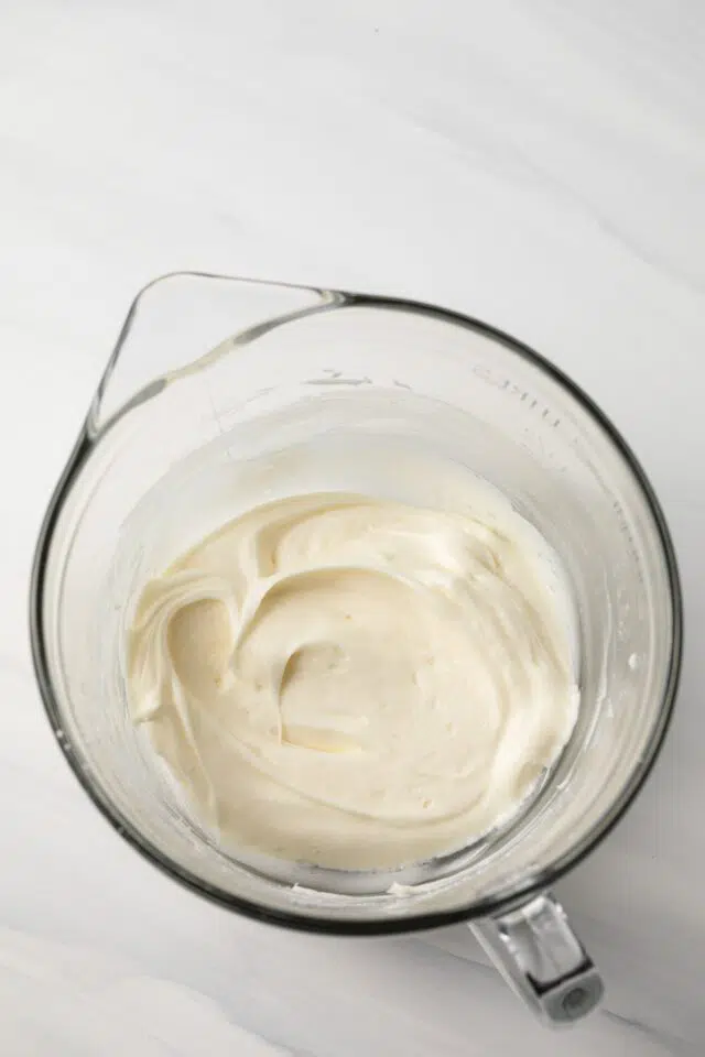 Cream cheese frosting in glass bowl.