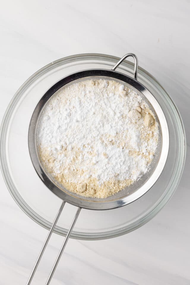 Almond flour and confectioners' sugar in a sieve.