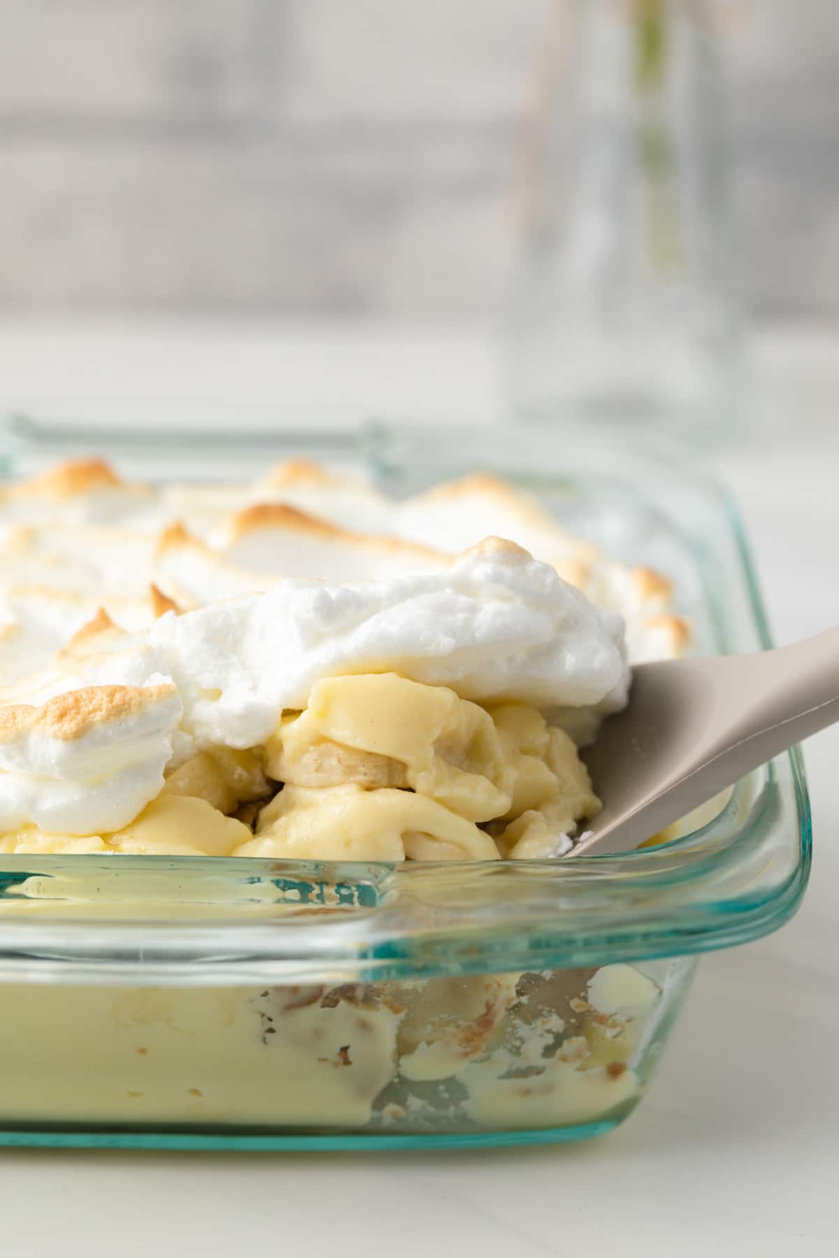 Spooning banana pudding out of a dish.