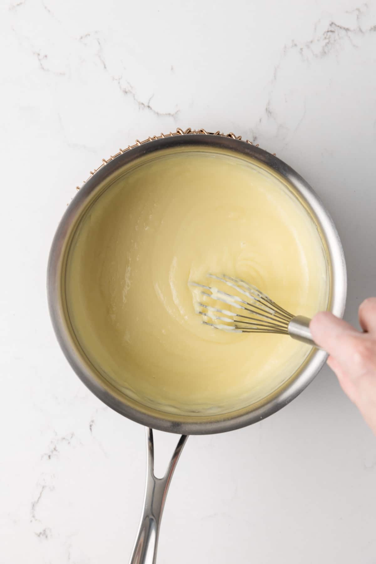 Cooked vanilla pudding in a pot.