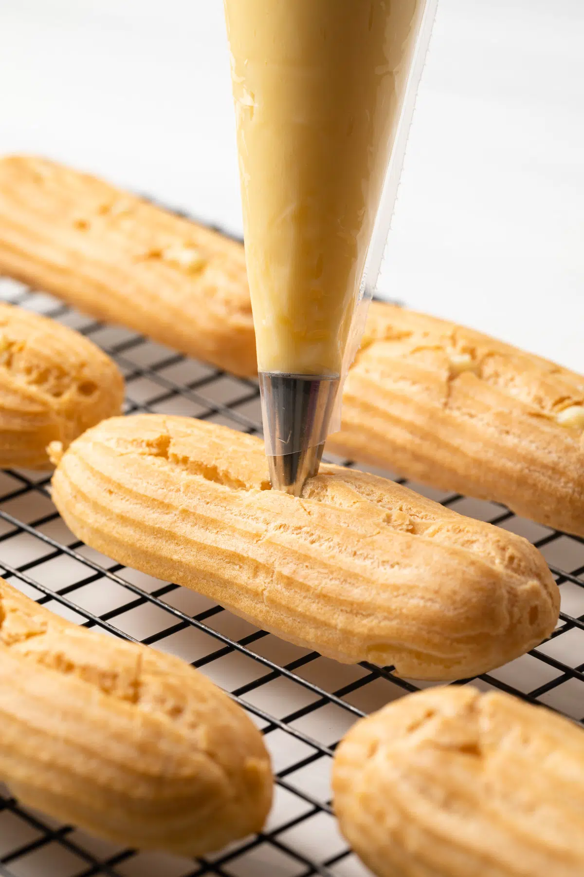 Filling eclair shells with pastry cream.