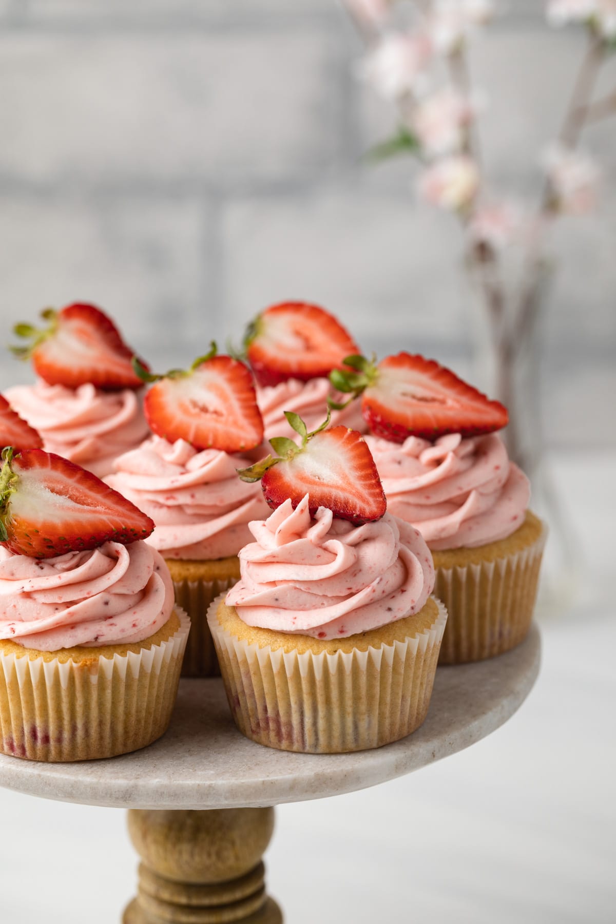 Angled view of strawberry cupcakes on cake stand.