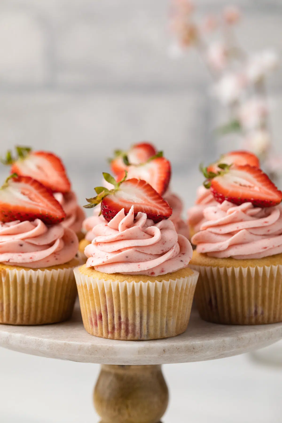 Strawberry cupcakes on cake stand.