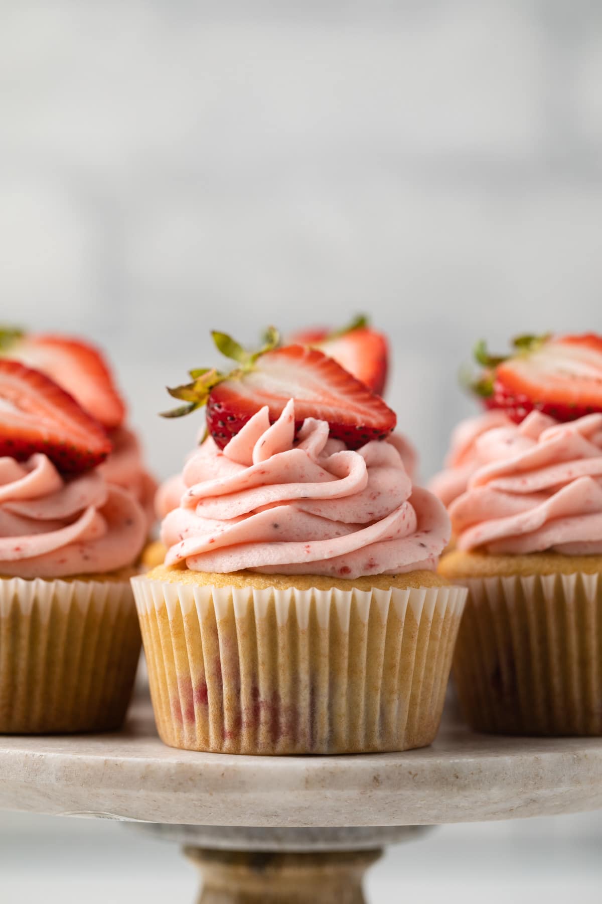 Close up of strawberry cupcakes on cake stand.