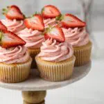 Angled view of strawberry cupcakes on cake stand.