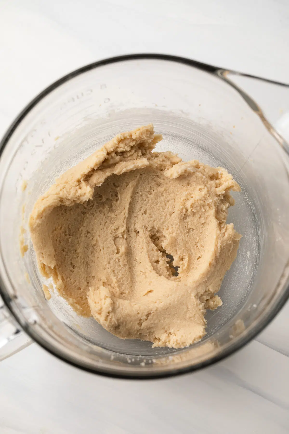 Butter and sugar creamed in a glass bowl.