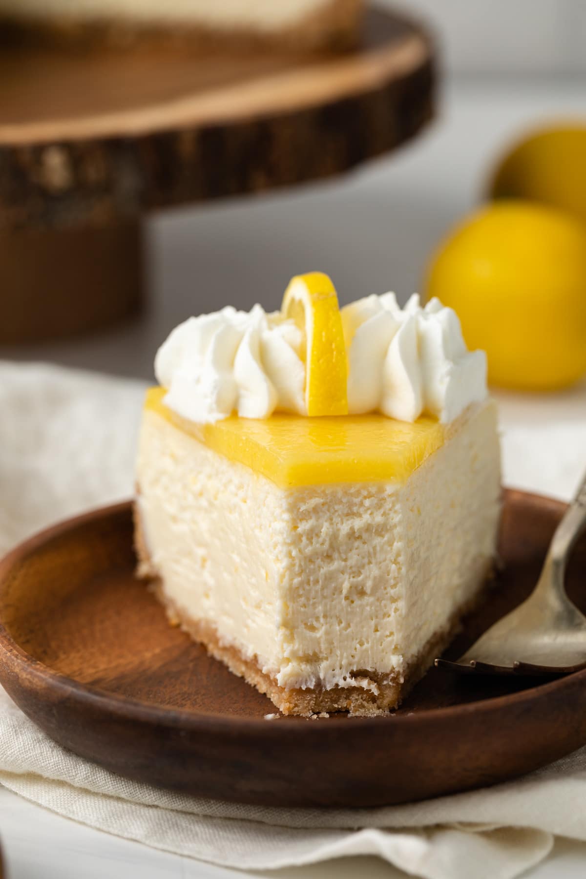 Slice of lemon cheesecake with a bite taken out.