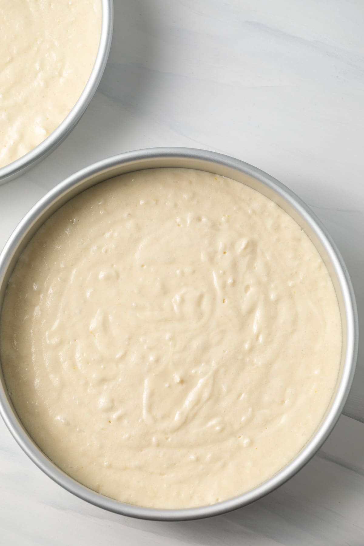 Coconut cake batter in cake round cake pans.