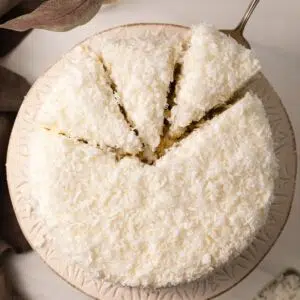 Overhead view of coconut cake with slices cut out.