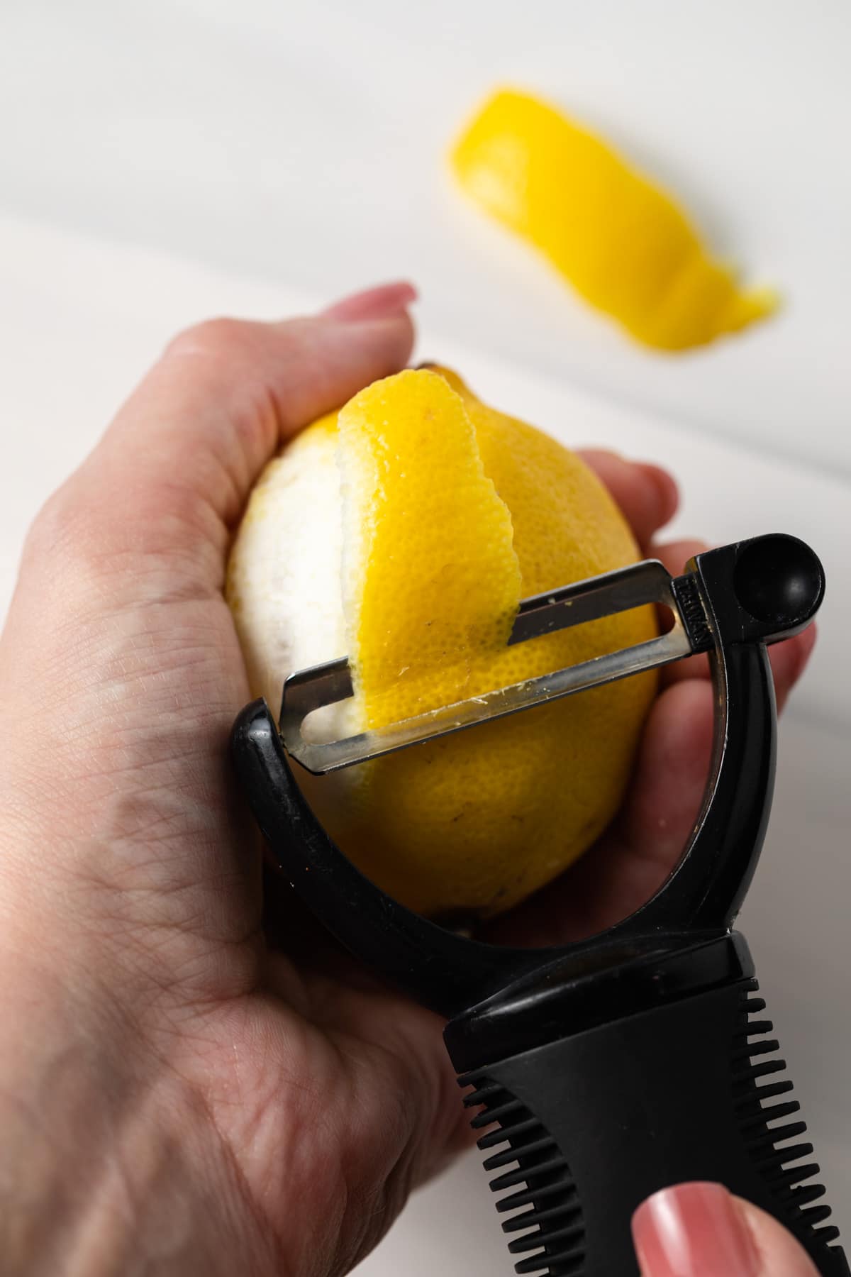 Zesting a lemon with a peeler.