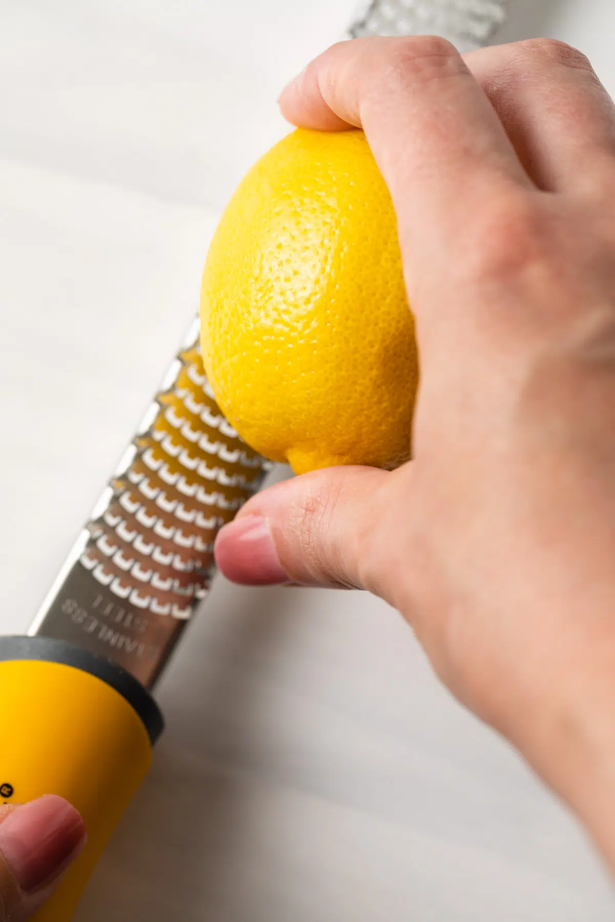 Zesting a lemon with a microplane.