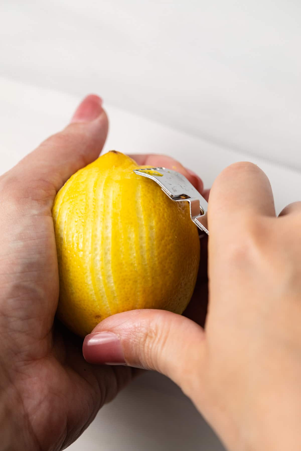 Zesting a lemon with a lemon zester.