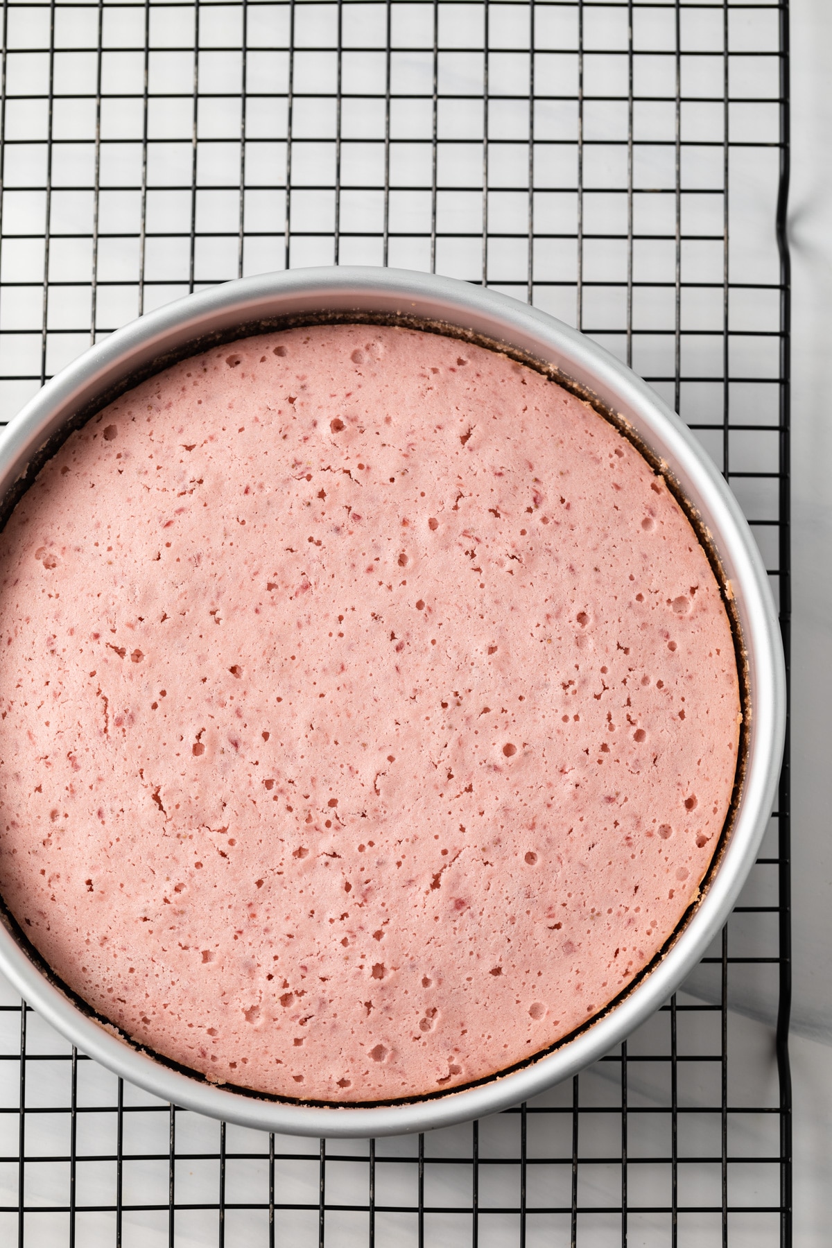 Baked strawberry cake in a round cake pan.