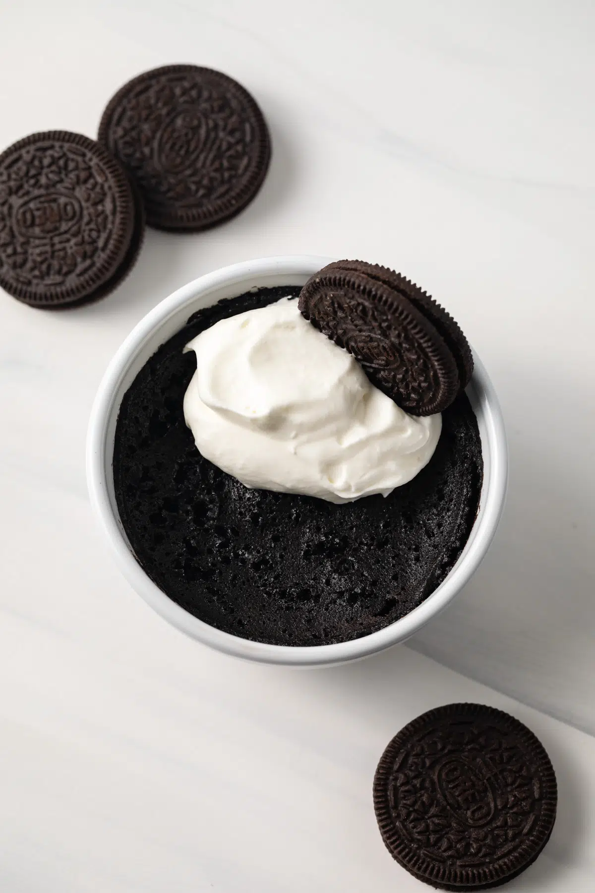 Overhead of Oreo mug cake topped with whipped cream.