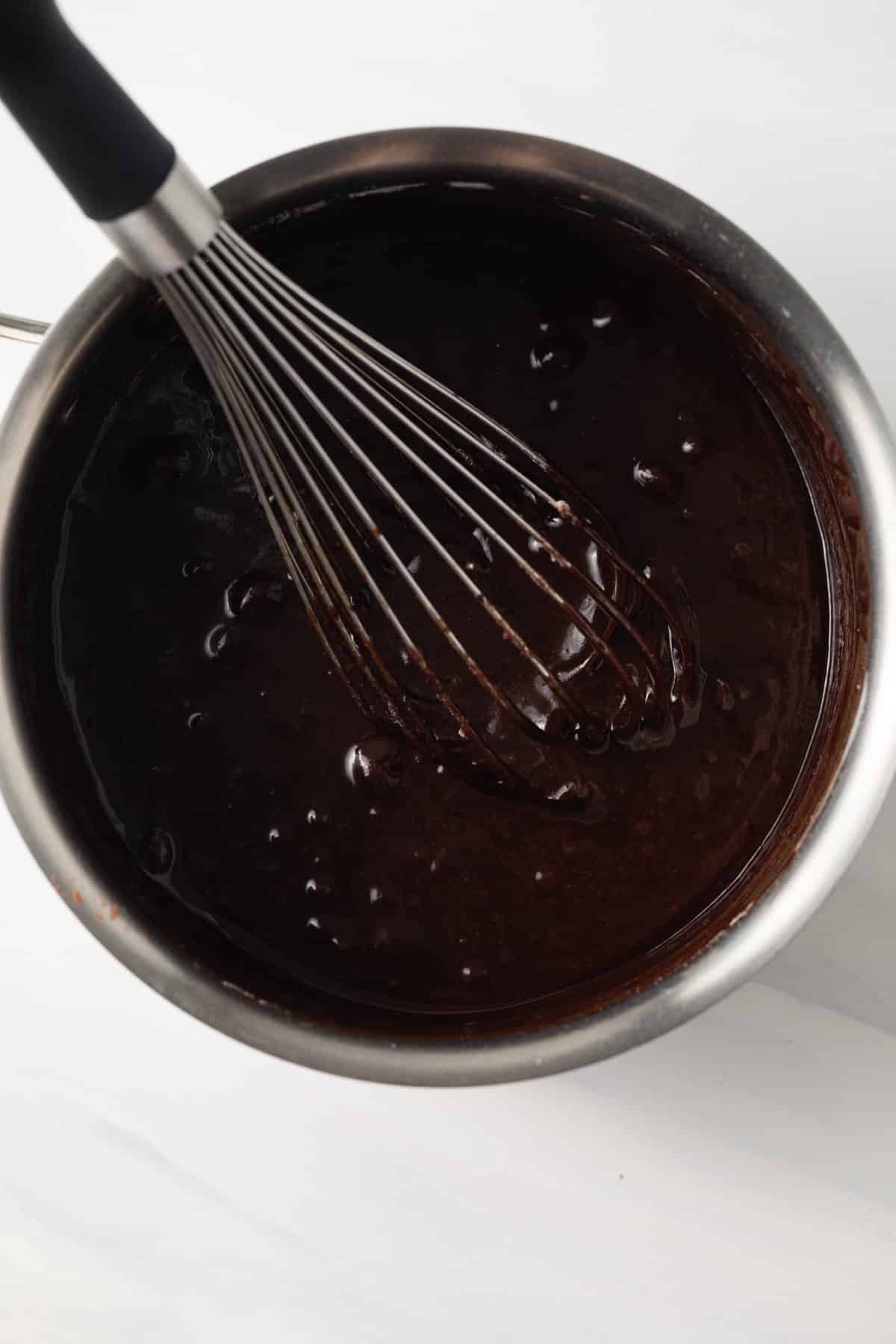 Brownie batter in pot with whisk.