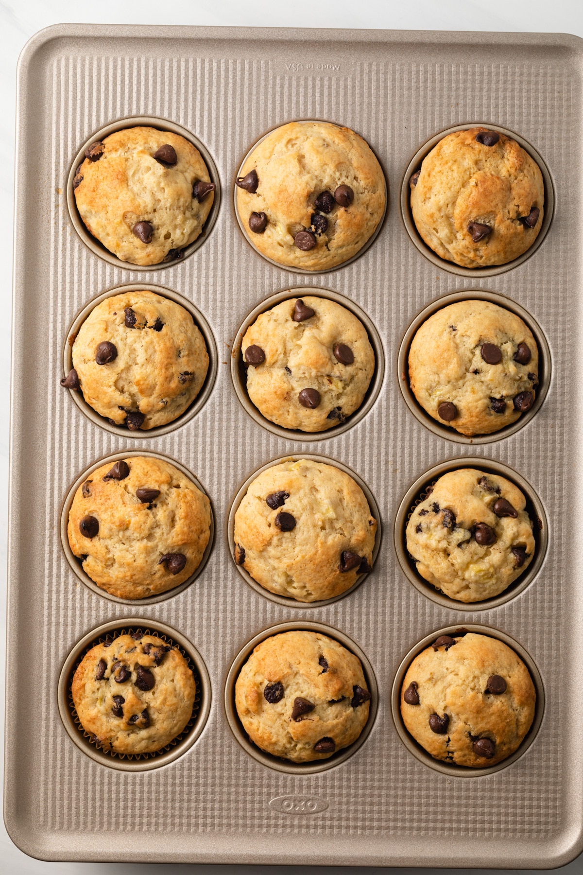 Baked banana chocolate chip muffins in muffin pan.
