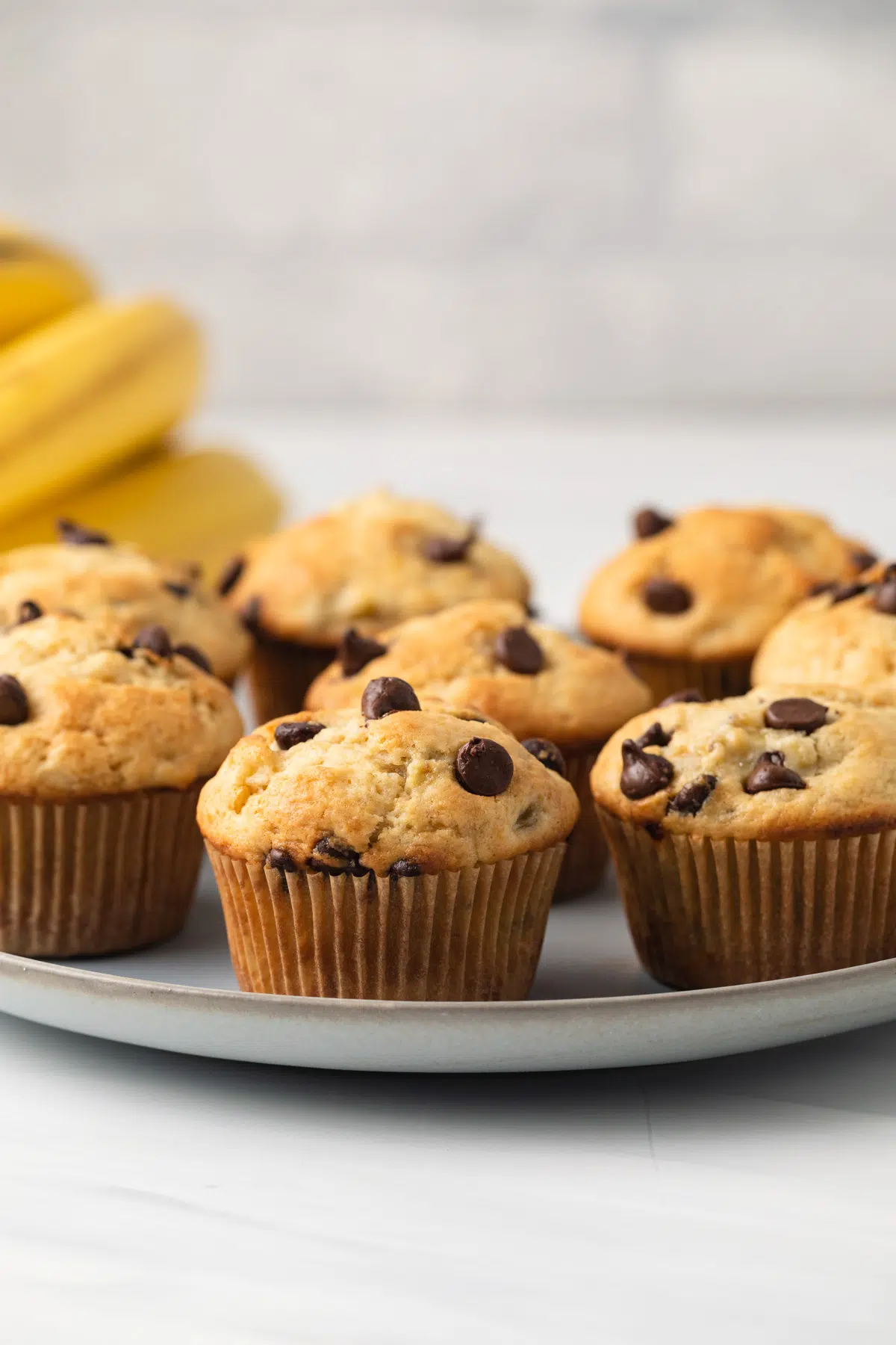 Side view of banana chocolate chip muffins on blue plate.