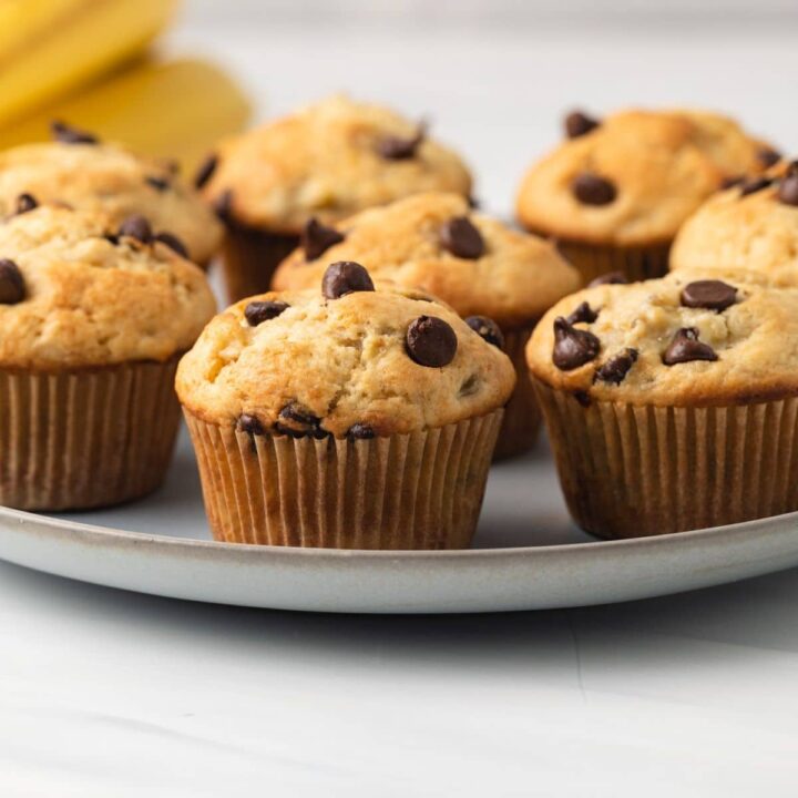 Side view of banana chocolate chip muffins on blue plate.