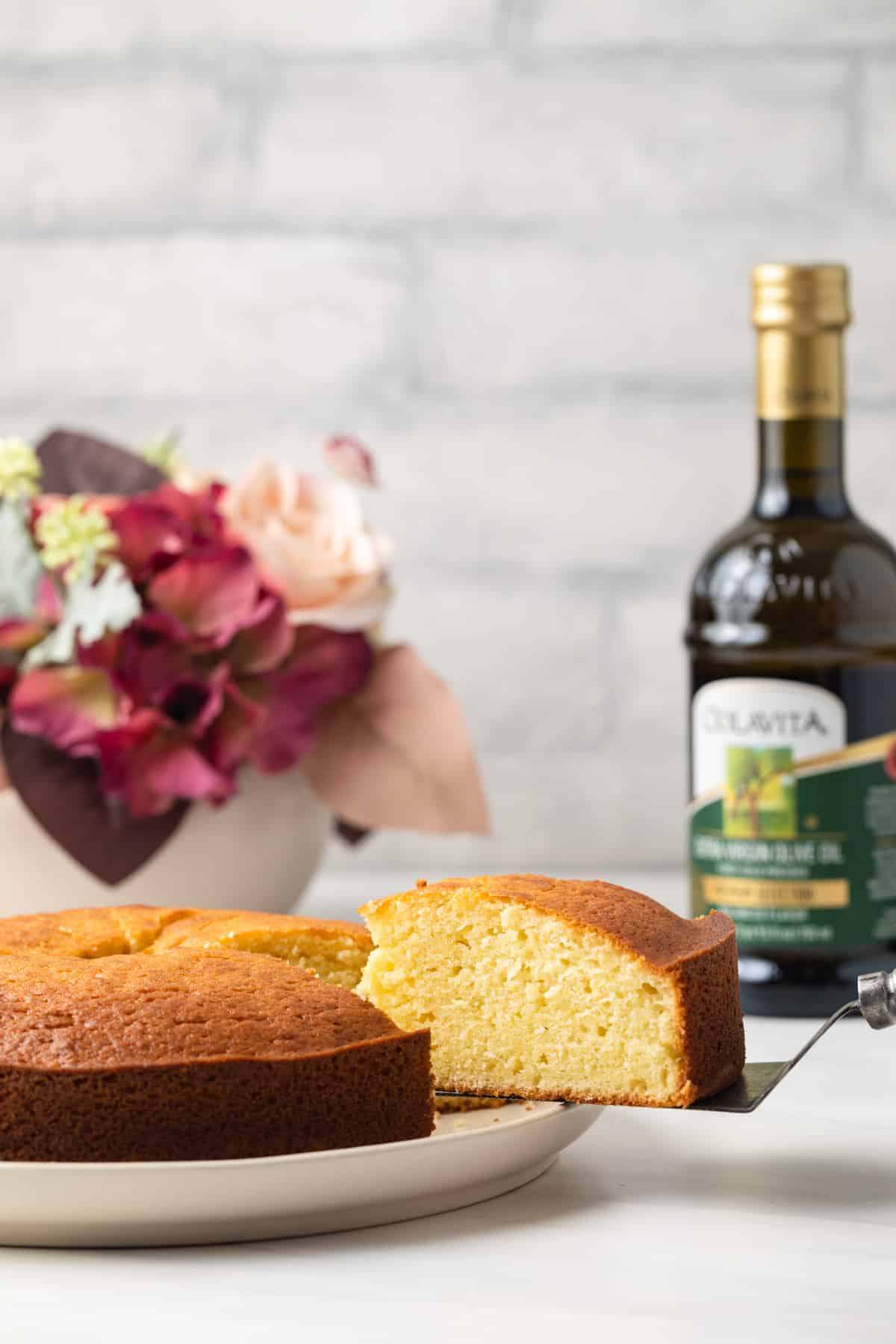 Slice being taken out of olive oil cake.